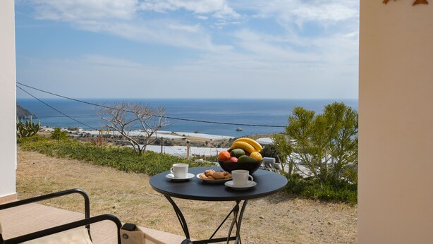 A table with a fruit bowl, cups, and cookies on a balcony overlooking the sea. - Angelika House -Amazing Sea view (Faistos)