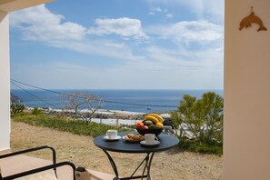 A table with a fruit bowl, cups, and cookies on a balcony overlooking the sea. - Angelika House -Amazing Sea view (Faistos)
