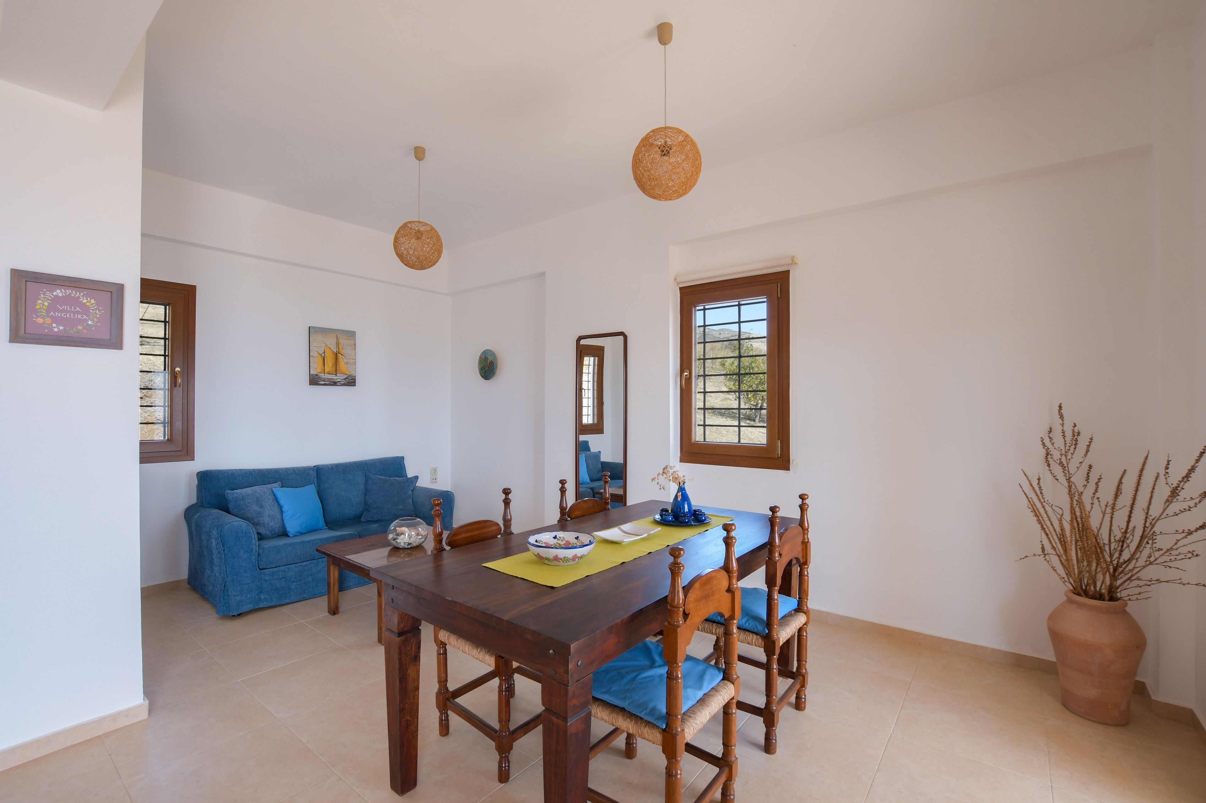 A dining area with a wooden table, blue chairs, and a blue sofa.