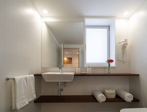 Enjoy a refreshing bathroom experience with a mirror, large window, and convenient towel storage.