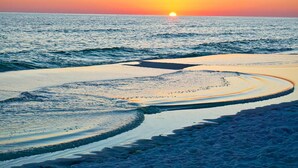 A beach with a sunset over the ocean. - Grandview East 304 (Panama City Beach)
