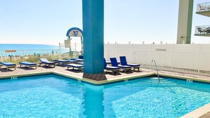 A swimming pool with blue lounge chairs, a lifeguard stand, and a sign indicating a non-smoking area. - Grandview East 1601 - Azure Paradise (Panama City Beach)