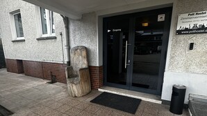 Entrada de un edificio con un cartel que dice 'Pott Hostel' y una zona de recepción.