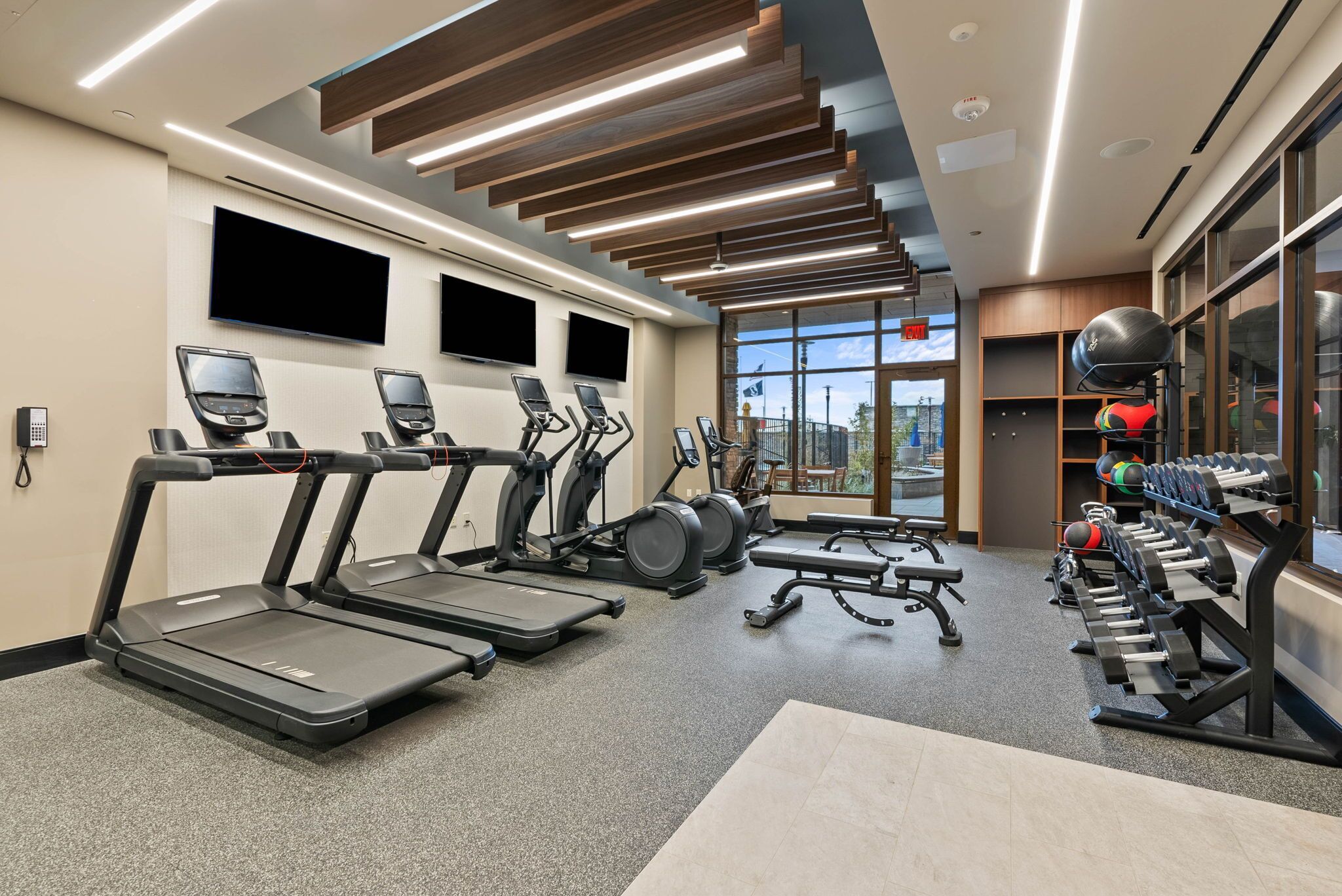 A modern gym with treadmills, stationary bikes, and weight machines.