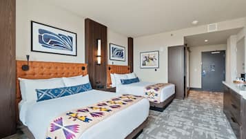 Habitación de hotel con dos camas, cabecera de madera y alfombra estampada.