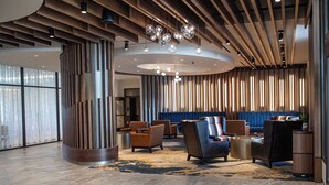 A modern lobby with a curved ceiling, wooden paneling, and a seating area with sofas and armchairs. - Spokane Tribe Resort and Casino (Airway Heights)