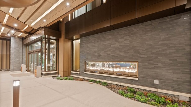 A modern lobby with a curved pathway, a glass entrance, and a decorative wall with a built-in display. - Spokane Tribe Resort and Casino (Airway Heights)