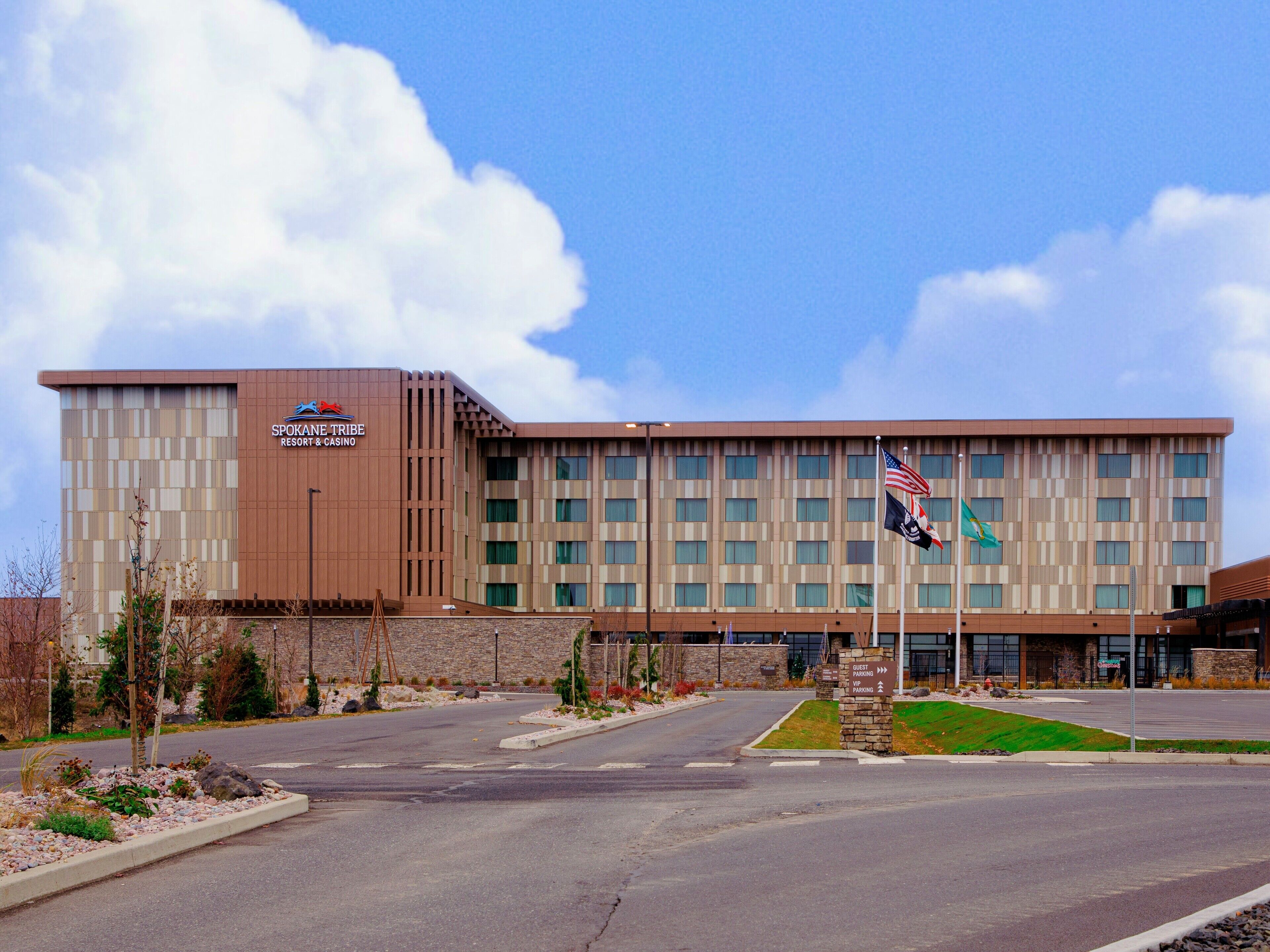 A modern building with a sign for Spokane Tribe Resort & Casino, featuring a large parking area and multiple windows.
