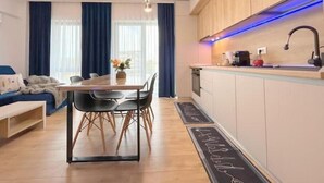 Moderni huoneisto, jossa on ruokailutila, keittiö ja sohva.