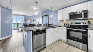 A modern kitchen with stainless steel appliances, white cabinets, and a large island.