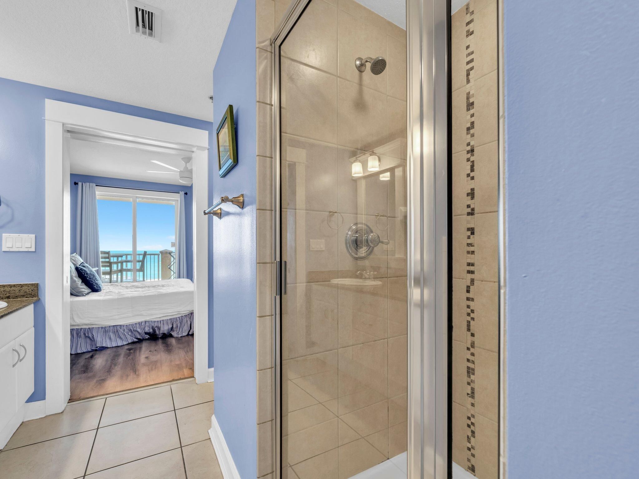 A bathroom with a glass shower enclosure, a visible toilet, and a sink.