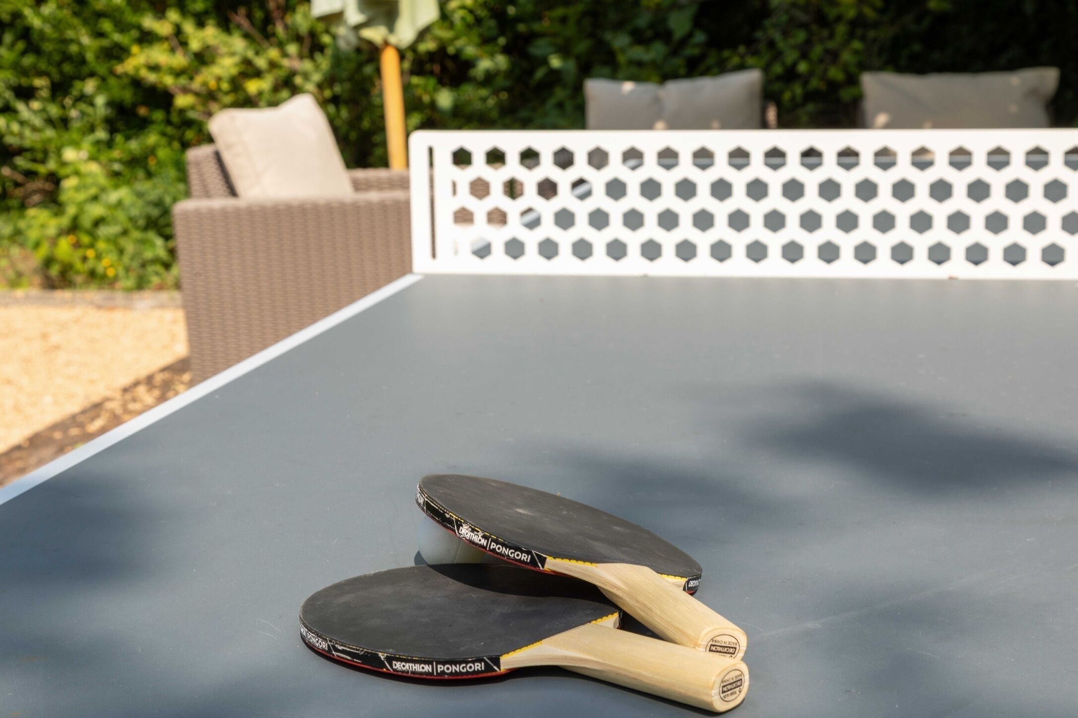 Une table de ping-pong avec deux raquettes au premier plan.