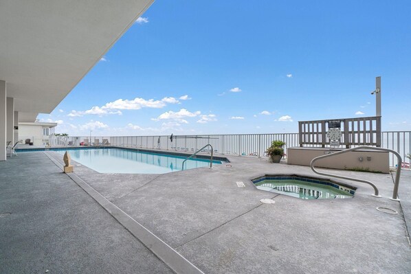 A rooftop pool with a clear view of the sky, a small hot tub, and a metal railing. - Windemere 708 (Pensacola)