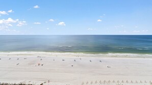 Une vaste plage de sable fin, avec un ciel dégagé et une mer calme.