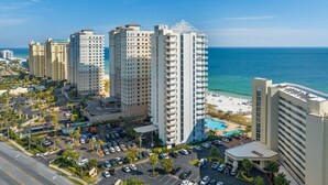 A high-rise hotel with a pool area, parking, and a view of the ocean. - Palacio 1803 (Pensacola)