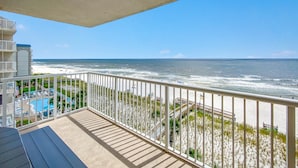 A balcony with a view of the ocean and a pool area. - Sandy Key 631 (Pensacola)