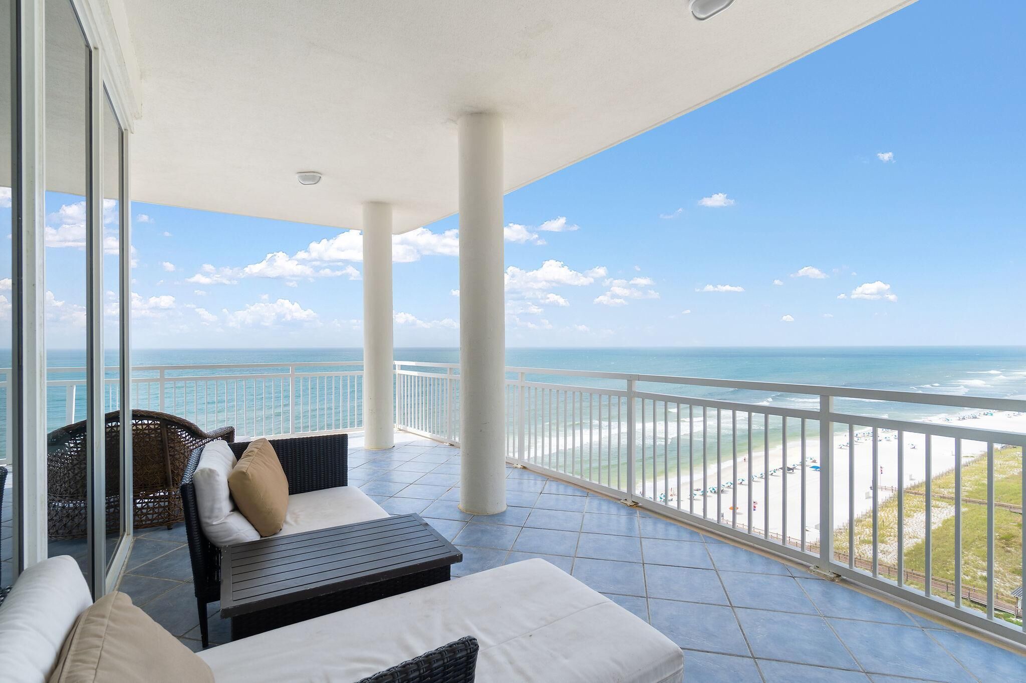 Un balcon avec vue sur l’océan, aménagé avec un canapé et une table.