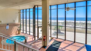 A hotel room with a pool, large windows with ocean views, and a ceiling fan. - Summerchase 1107 (Orange Beach)