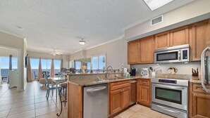 A modern kitchen with wooden cabinets, stainless steel appliances, and a large island. - Tidewater 609 (Orange Beach)