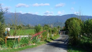 Un camino rural que lleva a un cartel que dice "TOTARA GLEN".