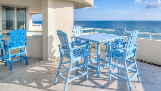 A balcony with a table and chairs, overlooking the ocean. - Perdido Sun 916 (Pensacola)