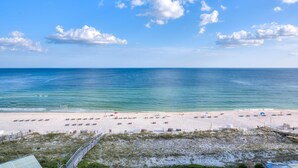 A beach with a clear sky, calm sea, and a sandy shore. - Perdido Sun 916 (Pensacola)