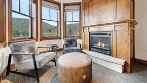 A cozy room with a fireplace, large windows, and comfortable seating. - The Aspen Mountain Residences 30A - Studio Residence (Aspen)
