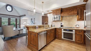 A modern kitchen with wooden cabinets, stainless steel appliances, and a large island.