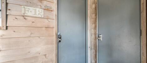 A wooden door with a metal handle and a number plate reading "F.12".