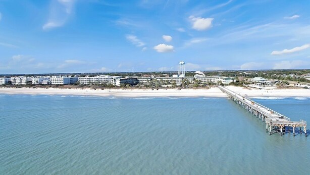 A coastal hotel with a pier extending into the water, beachfront rooms, and a clear sky. - 1 BR Top Floor Isle of Palms Oceanfront Condo | Pool | Free Wifi & Parking (Isle of Palms)