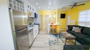A compact living space with a kitchen, dining area, and a sofa.
