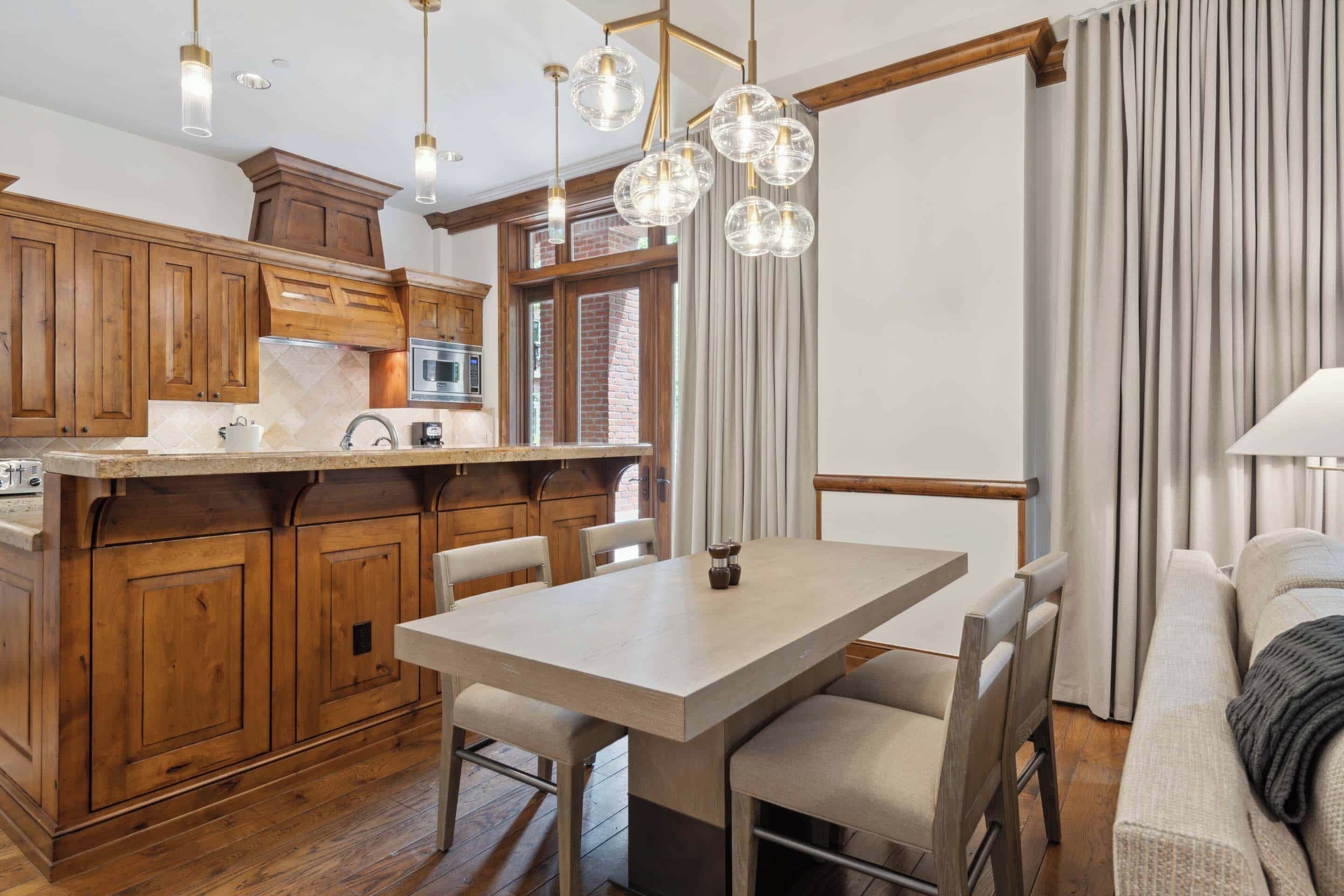Une cuisine moderne avec des meubles en bois, un îlot central et des luminaires suspendus.