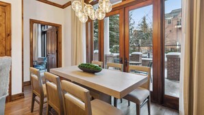 A dining area with a wooden table, chairs, and a chandelier.