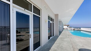 Ein Balkon mit Pool, Meerblick und ein Gebäude mit einem 'G'-Schild.