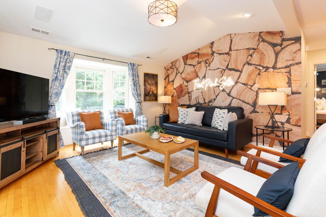 Ein Wohnzimmer mit einer Steinwand, einem Sofa, einem Couchtisch und einem Fernseher.