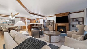 Un salón espacioso con chimenea, asientos cómodos, zona de comedor y cocina.