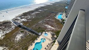 An aerial view of a resort with a beach, a bridge, and multiple swimming pools. - Phoenix Viii 1506 (Orange Beach)