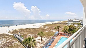 A beach view from a balcony with a pool and lounge chairs. - Seaspray West 503- Gulf Front (Pensacola)