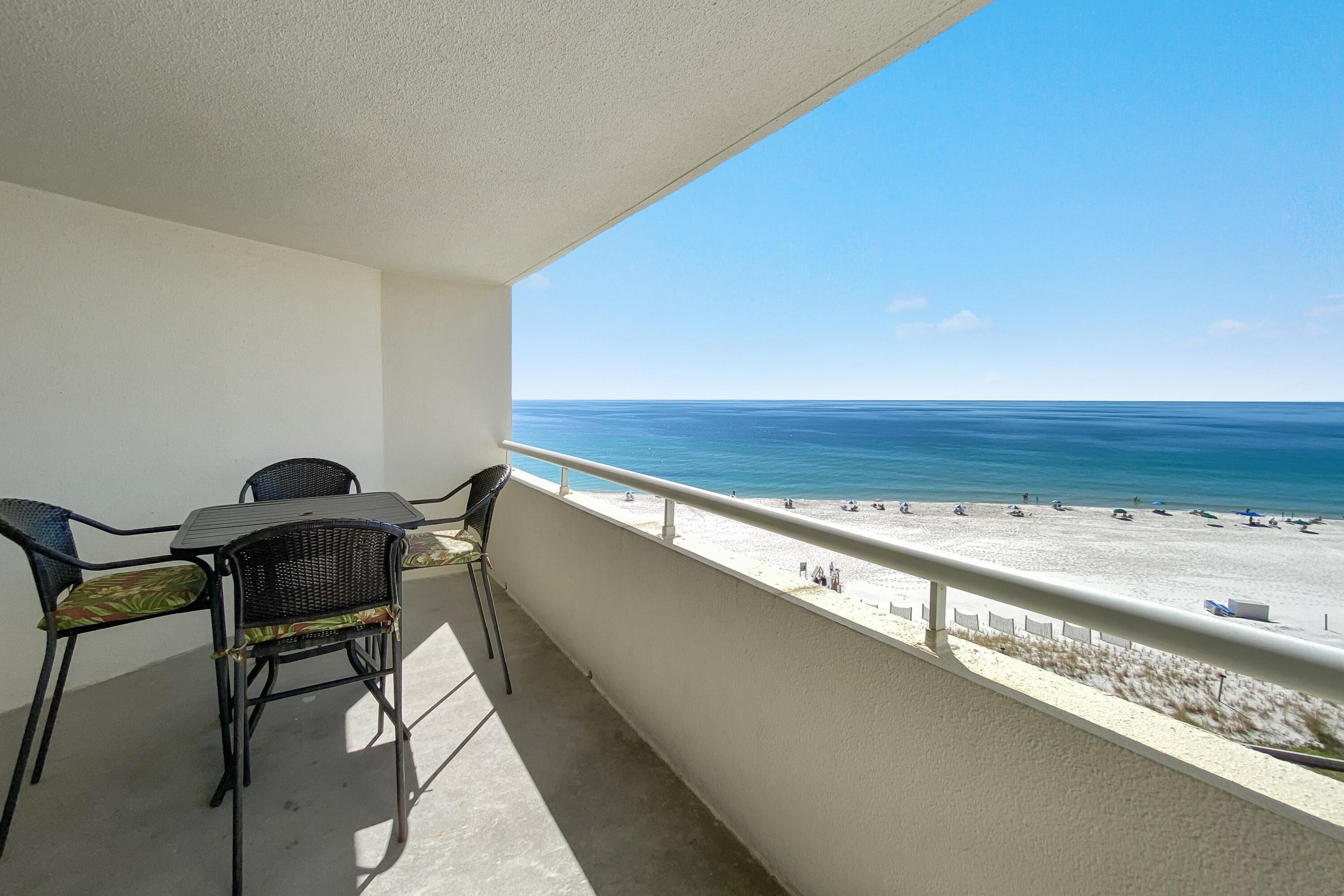 A balcony with a view of the beach and ocean.