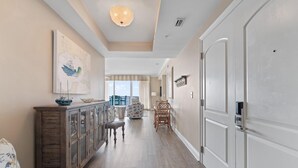 A hallway with a wooden cabinet, a chair, and a door.