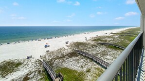 A beach view from a balcony with a wooden deck and a railing. - Shipwatch A804 (Pensacola)