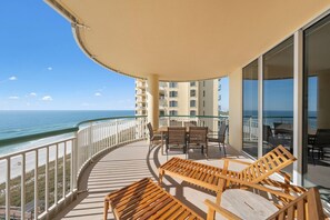 Relax on the balcony with ocean views, a comfortable seating area, and a table.