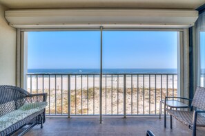 Un balcon avec vue sur la plage et l’océan.