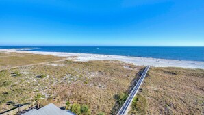 A coastal road leading to a beach with a clear sky. - Tidewater 706 (Orange Beach)