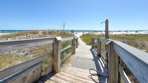 A wooden boardwalk leading to a beach with clear skies. - Summer House 1501b (Orange Beach)
