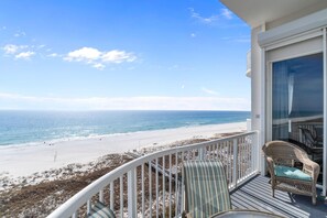 A balcony with wicker furniture overlooking a beach. - Spanish Key 702 (Pensacola)
