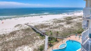 A beach view from a balcony overlooking a swimming pool and beach area. - Spanish Key 702 (Pensacola)