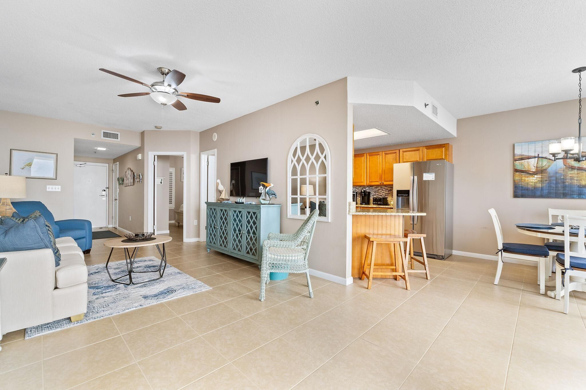 A modern living room with a sofa, a coffee table, and a dining area with chairs and a table.