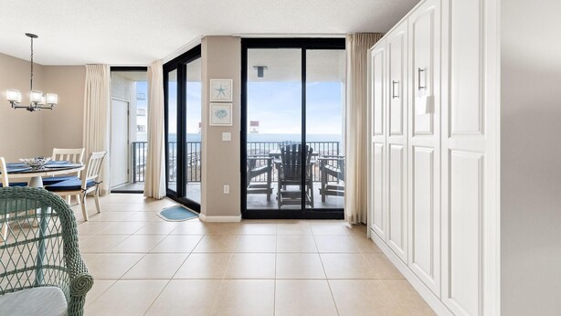Une chambre d’hôtel moderne avec balcon, un coin repas comprenant une table et des chaises, et une vue sur l’océan.