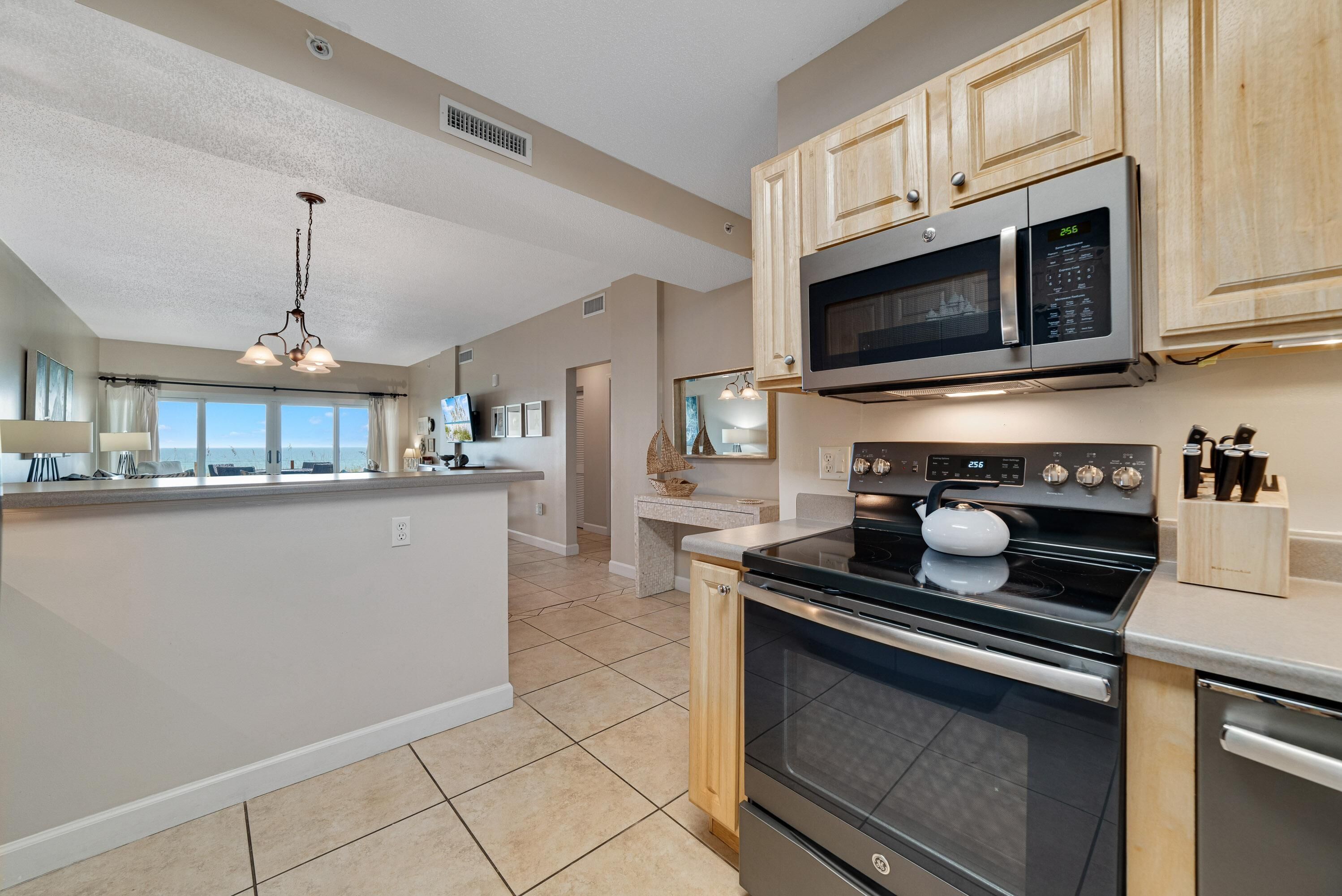 A modern kitchen with a central island, stainless steel appliances, and wooden cabinets.